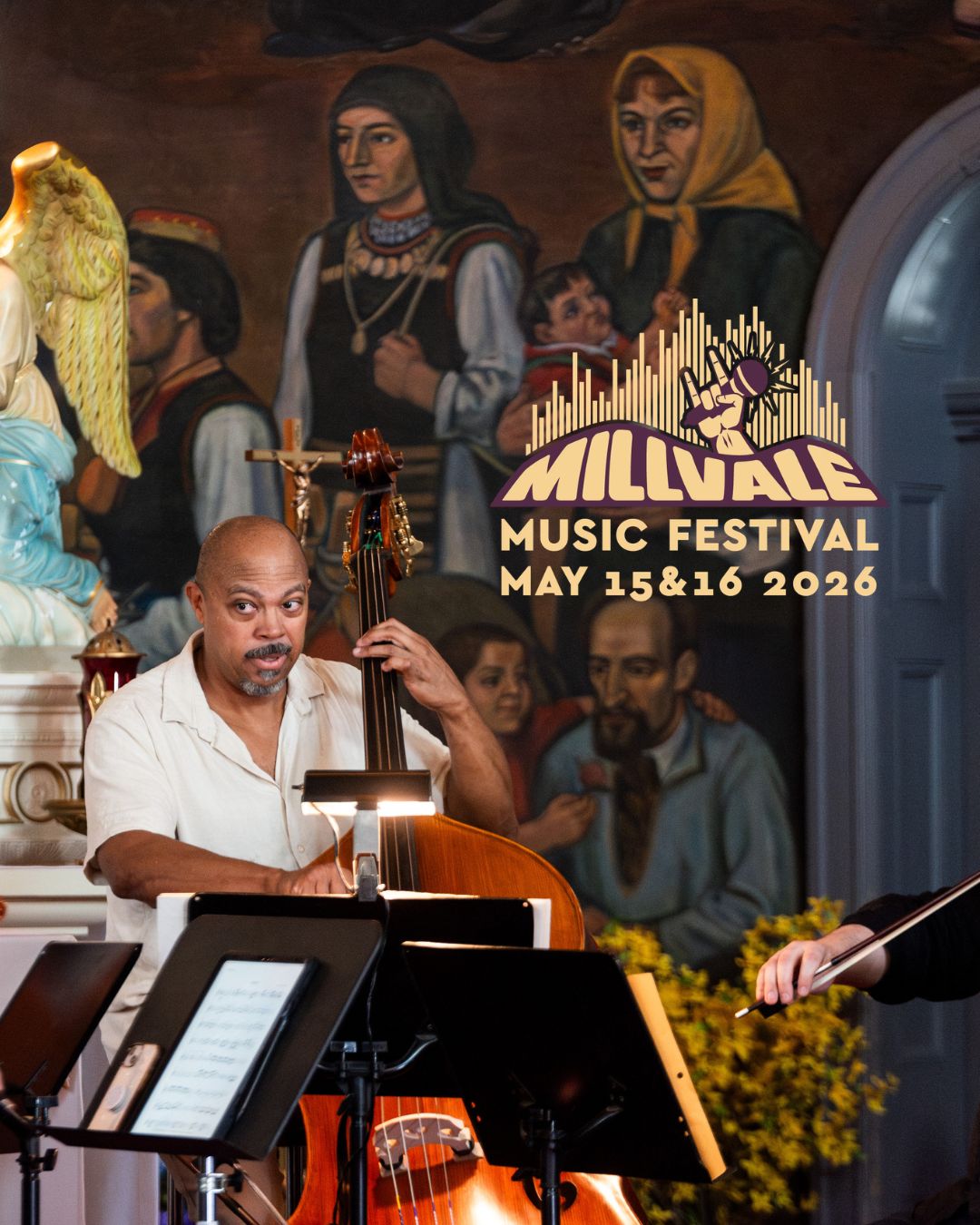 Rick Robinson plays upright bass in front of altar and murals at Saint Nicholas Catholic Church. Millvale Music Fest logo is over part of photo.