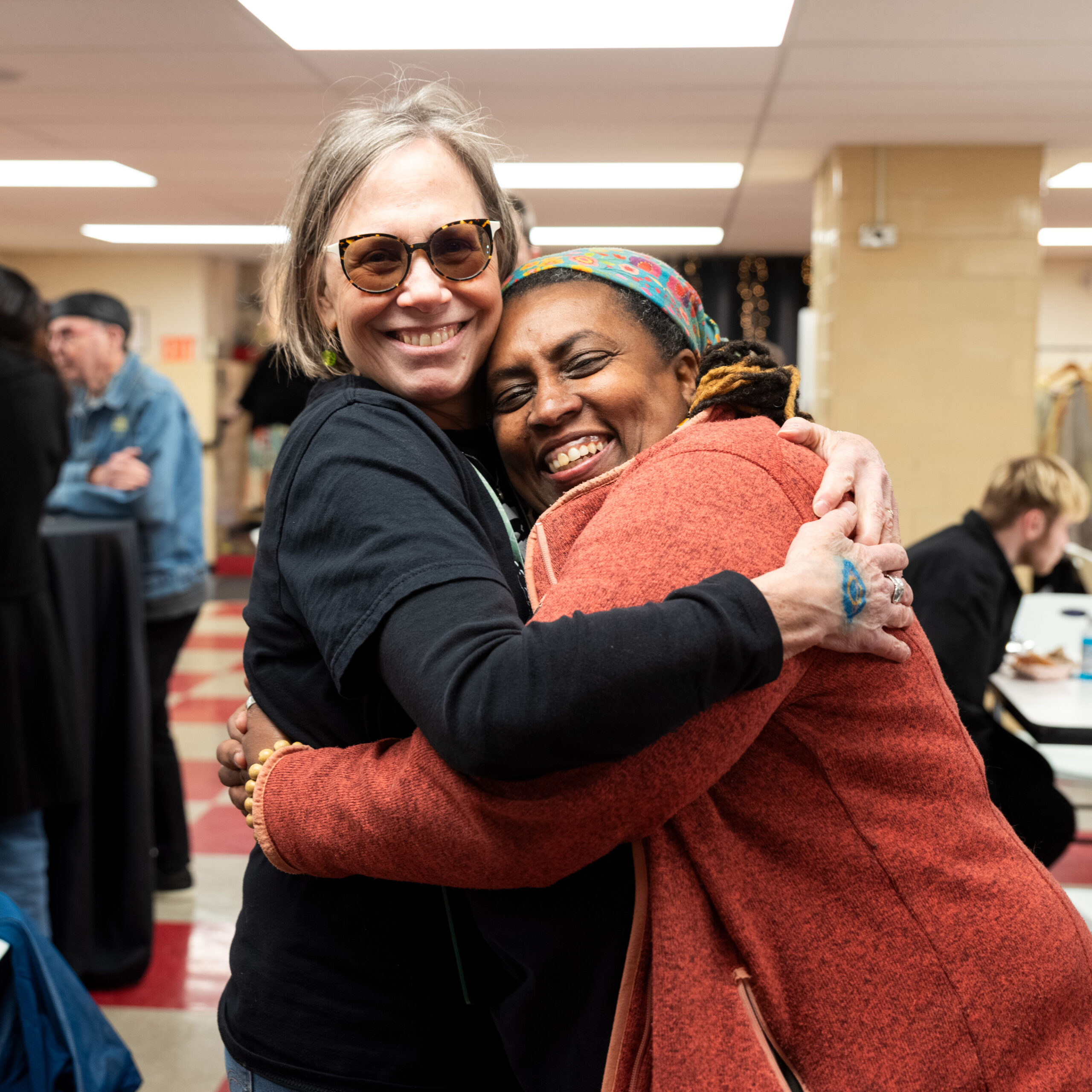 vanka-block-party-2026-anna-doering-michelle-king Two people hugging at Block Party indoors.