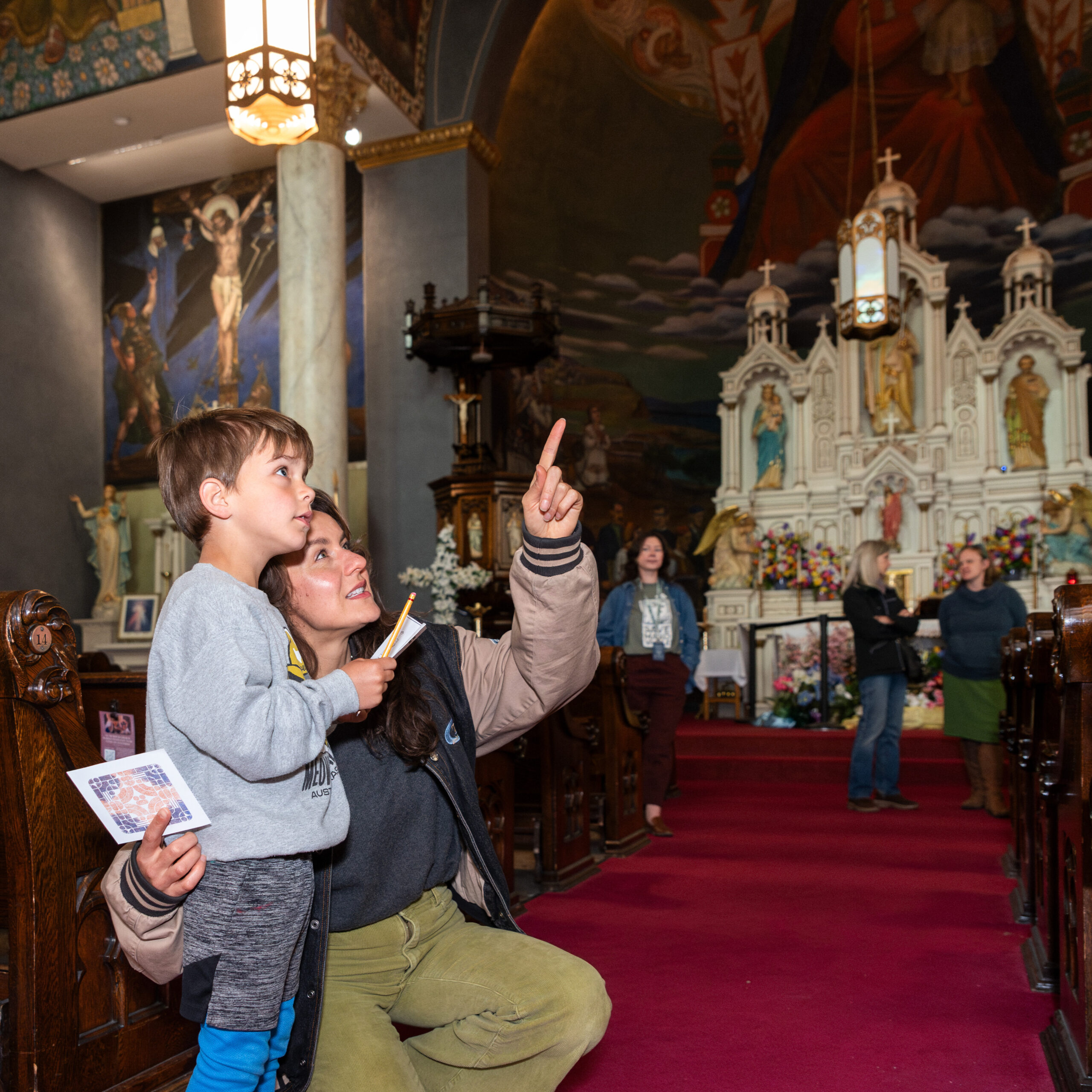 vanka-block-party-2026-family-murals Family pointing at murals inside church.